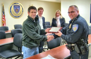 Lee Thornton, left, accepts a plaque for his family's donations to the K-9 unit from Lt. Nathan Beard, right, with Madison Police Department. Steven Thornton and Patricia Thornton look on. (CONTRIBUTED) 