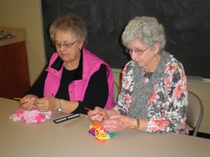 Ruth Wright, left, and Velma Herd work on scarves at Madison Senior Center.