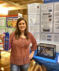 Liberty eighth-grader Katelin Baird shows her first-place ribbon at the regional science fair. Her bio-robotic hand is displayed in the case behind her. (CONTRIBUTED) 