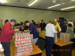 Volunteers stuff food packs for the We Care program in Madison. (CONTRIBUTED) 
