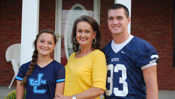 Danny Towry, center, divides her school loyalty between granddaughter Taylor Haraway at James Clemens and grandson Dylan Haraway at Bob Jones. (CONTRIBUTED) 