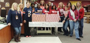 Heritage teachers supporting the Auburn Tigers stand at left and teachers rooting for the Crimson Tide stand at right for the "Alabama vs. Auburn Book Drive." (CONTRIBUTED) 