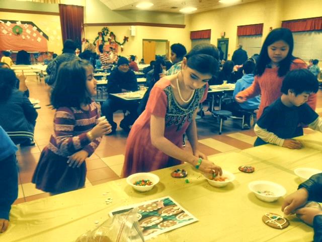 Students decorate gingerbread cookies during the English Learner International Festival at Heritage Elementary School. (CONTRIBUTED) 