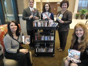 Sarah Haidar, back center, collected 780 DVDs to-date for Madison Hospital patients. Haidar received support from hospital volunteer director Kelly Hatley, clockwise from left, Mayor Troy Trulock, hospital president Mary Lynne Wright and Girl Scout leader Gretchen Perry. (RECORD PHOTO/GREGG PARKER)