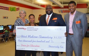 West Madison Principal Dr. Daphne Jah, second from left, accepts University Kia's $4,500 donation from general manager Arthur Seaton, second from right. Sally Bruer, coordinator of middle school instruction, and Kia sales manager Maurice Dobbins also attended the presentation. (CONTRIBUTED) 