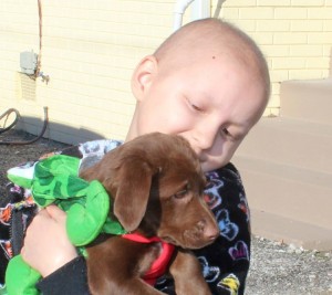 Sasha Dison hugs a puppy before her recent setback in dealing with cancer. Her fundraiser "TCP - Sasha's Way" (taking care of paws) will be held at Madison Station Bar & Grill, on April 29 at 4 p.m. (CONTRIBUTED) 