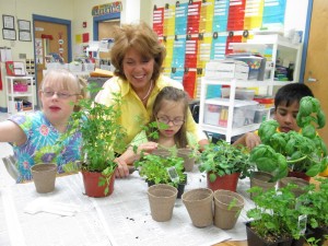 Susan Sanford, at center, inspects herbs for planting with her students Rylie Edwards, from left, Alex Kash and Ramana Krishnan at Columbia Elementary School (CONTRIBUTED)