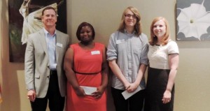 Madison Chamber of Commerce board members David Barrett, at left, and Amanda Weaver, at right, present scholarships to Monday Sanderson and Dylan Neal. (CONTRIBUTED) 