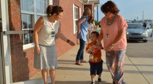 Assistant principal Angie Bush, at right, escorts a four-year-old student to a teacher at the Madison Pre-Kindergarten Center. (CONTRIBUTED) 