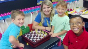 Kacie Aston's first-grade students Peyton Williams, from left, Caroline Zemnes and Camarious White are all smiles about their classroom's "Chess Center" at Rainbow Elementary School. (CONTRIBUTED) 