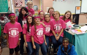 Liberty Middle School students and teacher Courtney Elrod, seated, wear their game-day T-shirts to help the Liz Hurley Breast Cancer Fund. (CONTRIBUTED) 