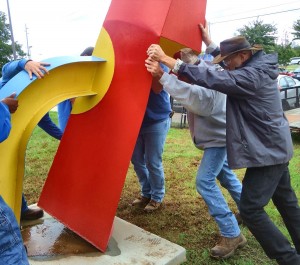 Sculptor Carl Billingsley, at right, helped Madison Public Works employees upright Billingsley's sculpture in the courtyard at Madison Elementary School. (RECORD PHOTO/GREGG PARKER)