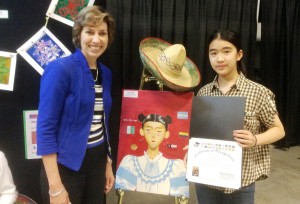 Discovery Middle School student Victoria Lee, at right, stands by her first-place winning artwork for Hispanic Heritage Month. Lee met Ellen Ochoa, America's first Hispanic female astronaut, who was featured speaker at the awards ceremony on Redstone Arsenal. (CONTRIBUTED) 