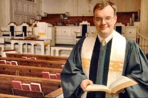 Rev. Travis Wilson stands in the sanctuary of one of Madison's oldest church congregations, Madison United Methodist Church (CONTRIBUTED) 