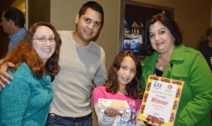 Annabelle Pereira from Heritage Elementary School holds her winning art entry in Madison Fire and Rescue Department's "Truck and Treat" art contest. Joining Annabelle on the fire truck ride were her parents Brandie and Robert Pereira, from left, and Heritage assistant principal Sharon Nichole Phillips. (CONTRIBUTED)  