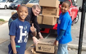 At Madison Elementary School, student council members Jonathan Hammonds, at left, and Malachi Bailey, at right, help Larry Ward with Inside-Out Ministries load canned food donated during the school's collection drive. (CONTRIBUTED) 