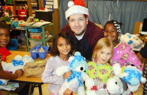 Morris Elementary School first-graders happily receive stuffed animals from Anthony Graham, founder of RUFF (Ready yoUrself For the Future). RUFF boys and Discovery Middle School students donated the Christmas gifts. (CONTRIBUTED) 