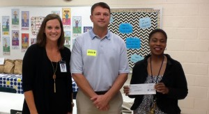 Principal Dr. Daphne Jah, at right, accepted a Public Education Leadership Community grant for $1,000 to West Madison Elementary School from Paul Wright with PPG Aerospace. School counselor Stephanie Allen assisted with the grant proposal. (CONTRIBUTED) 