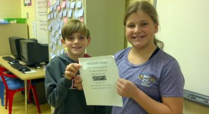 Heritage Elementary School fourth-graders Walker Hallman and Anastasia Snow hold a flier for "Walking Paws," a dog-walking business. (CONTRIBUTED) 
