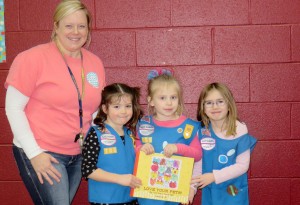Lisa D'Antonio, media specialist at Heritage Elementary School, congratulates Daisy Scouts Allison Parsons, from left, Penny Holloway and Gabby Burns on their book, "Love Your Pets," which Penny is holding. Rachel Holloway and Stephanie Cofer are Troop 700 leaders. (CONTRIBUTED/"HERITAGE TIMES")