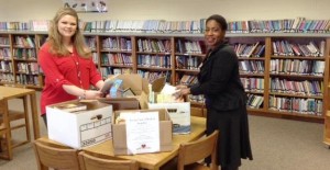 Emily Wolfe, at left, and Dr. Daphne Jah, media specialist and principal at West Madison Elementary School, sort books from the "For the Love of Reading" drive by Southern Scape landscaping service. (CONTRIBUTED) 
