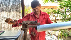 A Honduran villager with a sheet aluminum business works on an EcoStove chimney, one of his sources of income. Before Madison Rotarians and villagers build EcoStoves, local coordinator Carolina Tercero counts a village's houses and orders chimneys. (CONTRIBUTED)