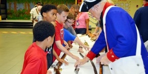 Dressed in authentic military attire, a member of Sons of the American Revolution shows a musket, bayonet and other weapons from the Revolutionary War to students at Columbia Elementary School. (CONTRIBUTED)