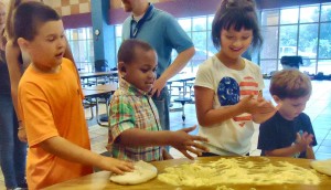 Denver Patterson, from left, Cameron Teague, Hyland Walfield and Andrew Williams learn to make cheese pizza during the Extended School Year (ESY) program, which convenes at Mill Creek Elementary School. (RECORD PHOTO/GREGG PARKER)