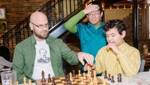 In Tuscaloosa, former U.S. chess champion Stuart Rachels, at left, plays chess with Cameron Baker of Madison, at right, as Douglas Zhang of Madison looks on in astonishment. Rachels will compete with Madison City Chess League members on June 27-28. (Photo/ Scott Wilhelm)