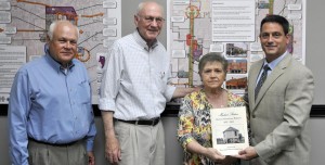 Mayor Troy Trulock, at right, accepts a copy of "Madison Station - Historic Downtown Madison, 1857-2015" from Madison Station Historical Preservation Society members Doug Smith, from left, John Rankin and Marsha Willis. (Record photo/Nick Sellers)