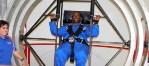 Assisted by an U.S. Space & Rocket Center employee, Carol Heinse shows her determination on the multi-axis trainer during the Space Academy for Educators. (CONTRIBUTED) 