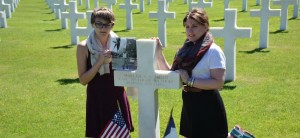 Following her eulogy, Erin Stender, at left, pauses with Erin Coggins at the grave of Capt. Malcolm A. Smith, originally from Birmingham and buried during World War II in an American cemetery in Normandy, France. (CONTRIBUTED)  