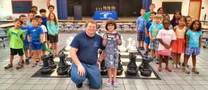 Coach Noel Newquist congratulates top camper Haley Clark during the "Learn to Play Chess" class at the Summer Knights Camp and Tournament. (CONTRIBUTED) 
