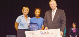 Maya Barnes, center, accepts her awards as District Staff Member of the Year. Presenting the $5,000 check to Barnes are the 2014 honoree, Karey Holcombe from James Clemens High School, and superintendent Dr. Dee Fowler. (CONTRIBUTED) 