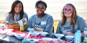 At the Sparkman Arts Festival, these members of Future Teachers of Alabama, complete with face painting, hosted a crafts table for sand art. (Contributed/Eden Lauren Photography)