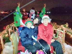 Ethan Worcester, recording artist Cristina Lynn and Zach Langston greet spectators from Madison Chamber of Commerce's float at the Madison Christmas Parade. CONTRIBUTED