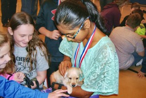 Avaini Singireddy, a student at Mill Creek Elementary School, cuddles a puppy from Madison Small Pups Adoption and Rescue. Singireddy ranked in second place among girls at the Maverick Shootout Archery Tournament. CONTRIBUTED