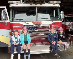 St. John students Eric Joyce, from left, Nora Pacheco, Ryan French and Ava Neese visited Madison firefighters during National Catholic Schools Week 2016. CONTRIBUTED