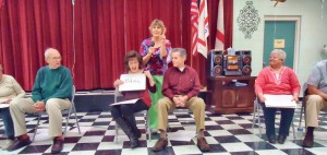 Joyce Duncan, at center, reveals her answer to husband Curt Duncan during the "The Not-So-Newlywed Game" as Vickie Parker moderates. Contestants looking on are Don Rice, at left, and Pat Ortman, at right. RECORD PHOTOS/GREGG L. PARKER