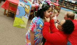 A Target employee helps a student with makeup for the Dr. Seuss Cafe at West Madison Elementary School.  CONTRIBUTED