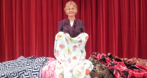 Debbie Anderson stands by the lap blankets that she made for the Norsworthy children. CONTRIBUTED