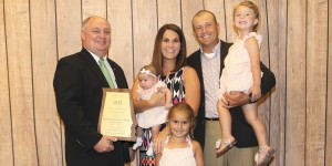 Alabama Farmers Federation President Jimmy Parnell, at left, presents a plaque to Outstanding Young Farm Family winners Stewart and Kasey McGill and their children Allie, Reece and Peyton. CONTRIBUTED
