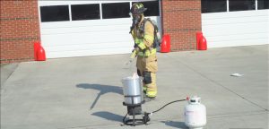 A uniformed firefigther drops the turkey in boiling oil in the fryer. RECORD PHOTOS/GREGG L. PARKER 