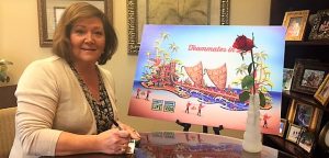 Mary Lynne Weight, President of Madison Hospital, signs a rose vial for Alabama Organ Center's float in the Rose Parade. Wright sits near a rendering of the float. CONTRIBUTED