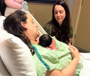 Kristine Taff, registered nurse and lactation consultant, (at right) discusses benefits of skin-to-skin contact between mom and baby with a patient and her baby girl, born on Dec. 21. CONTRIBUTED