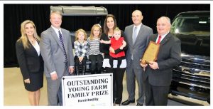 Wendy Tysinger, from left, with Alabama Farm Credit and Doug Thiessen with Alabama Ag Credit congratulate Alabama Outstanding Young Farm Family Kasey and Stewart McGill and daughters Reece, Allie and Peyton. Alabama Farmers Federation President Jimmy Parnell stands at right. CONTRIBUTED